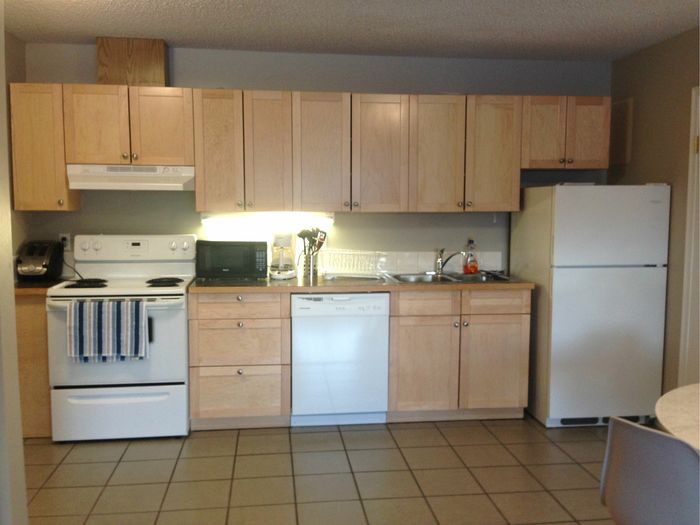 Modern kitchen with sleek cabinets, white appliances, and ample counter space, perfect for cooking enthusiasts.