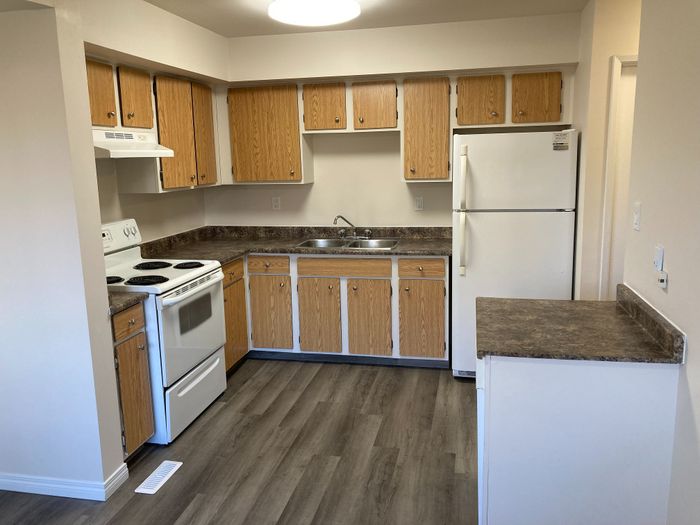 Cozy kitchen with wood cabinetry, modern appliances, and sleek countertops offers a perfect blend of style and functionality.