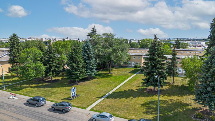 Charming apartment community surrounded by lush greenery and mature trees, offering a serene suburban lifestyle.