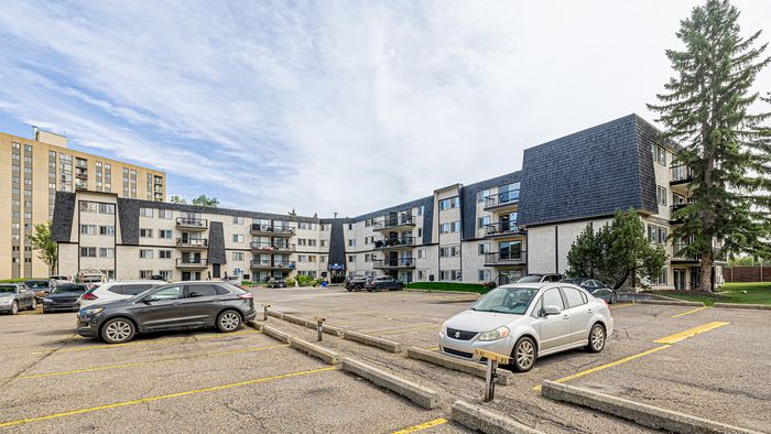Charming apartment complex with modern design, ample parking, and lush greenery, ideal for comfortable living.