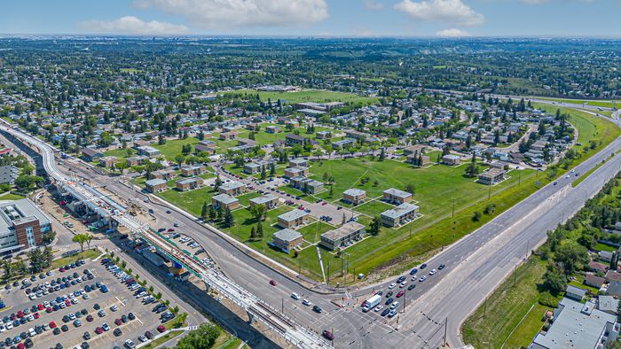 Aerial view of a vibrant residential community featuring modern apartment buildings, lush green spaces, and convenient access roads, portraying a lively, well-connected neighborhood.