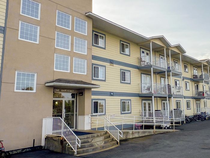 Modern apartment building with multiple balconies and large windows, offering stylish urban living.