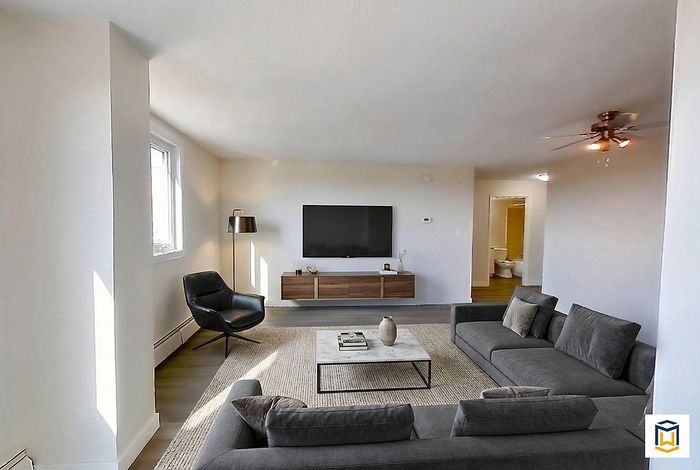 Contemporary living room featuring stylish gray sofas, modern TV setup, and a chic minimalist design.