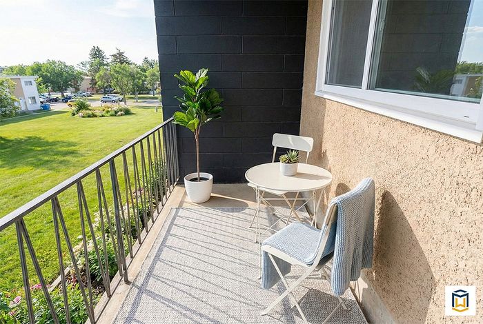 Inviting balcony with stylish seating, lush greenery, and scenic views of a vibrant green park, perfect for relaxing afternoon retreats.