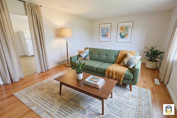 Inviting living room with a stylish green sofa, warm wooden coffee table, and modern decor, creating a cozy and contemporary ambiance.