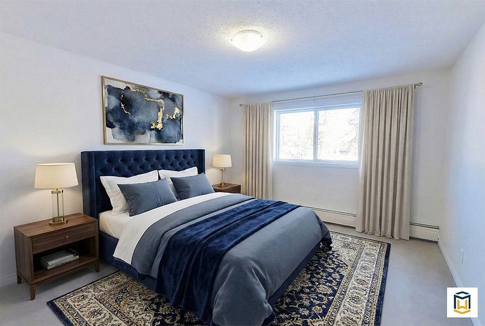 Elegant bedroom featuring a plush navy blue bed, chic artwork, and large window for natural light.