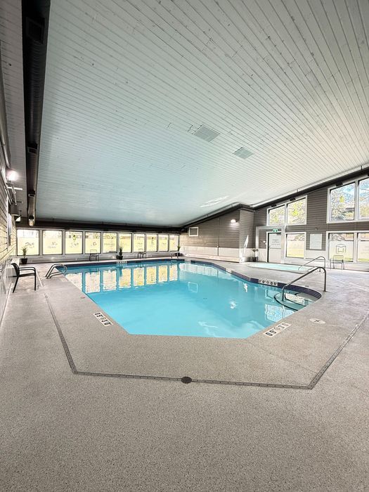 Inviting indoor swimming pool with bright windows and modern design, perfect for relaxation and exercise all year round.