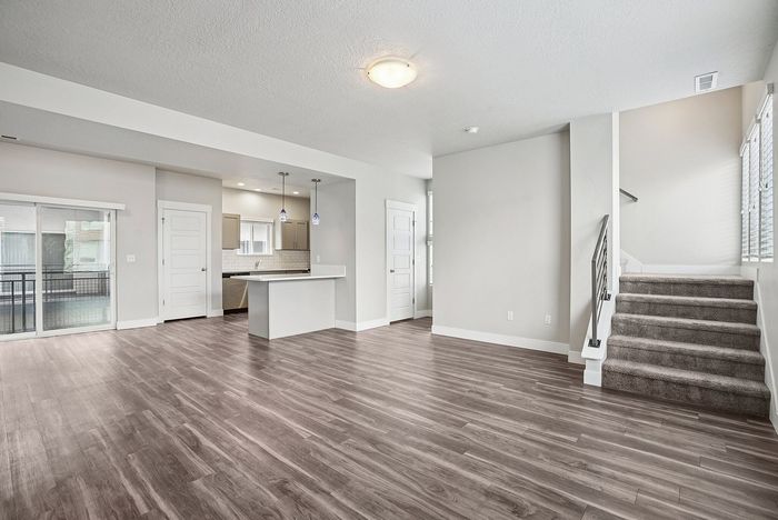 Charming residential building surrounded by lush greenery and vibrant autumn trees, featuring multiple balconies perfect for enjoying the scenic views.