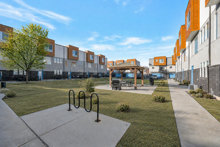 Charming residential building surrounded by lush greenery and vibrant autumn trees, featuring multiple balconies perfect for enjoying the scenic views.