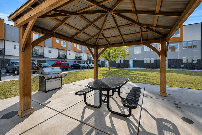 Charming residential building surrounded by lush greenery and vibrant autumn trees, featuring multiple balconies perfect for enjoying the scenic views.