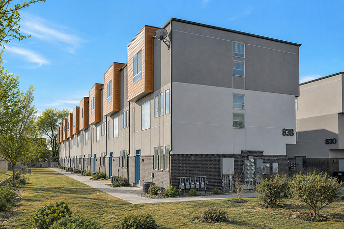 Charming residential building surrounded by lush greenery and vibrant autumn trees, featuring multiple balconies perfect for enjoying the scenic views.