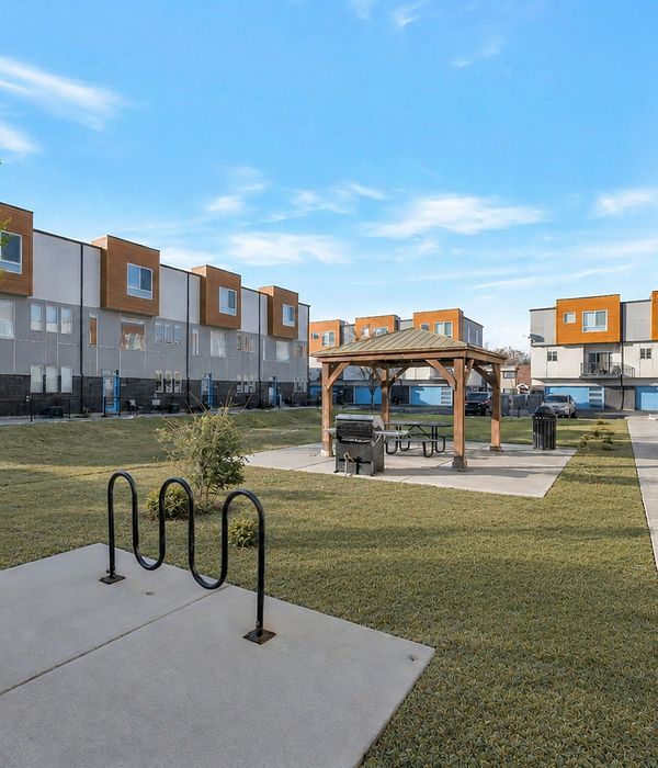 Charming residential building surrounded by lush greenery and vibrant autumn trees, featuring multiple balconies perfect for enjoying the scenic views.