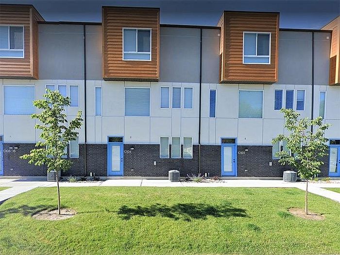 Charming residential building surrounded by lush greenery and vibrant autumn trees, featuring multiple balconies perfect for enjoying the scenic views.