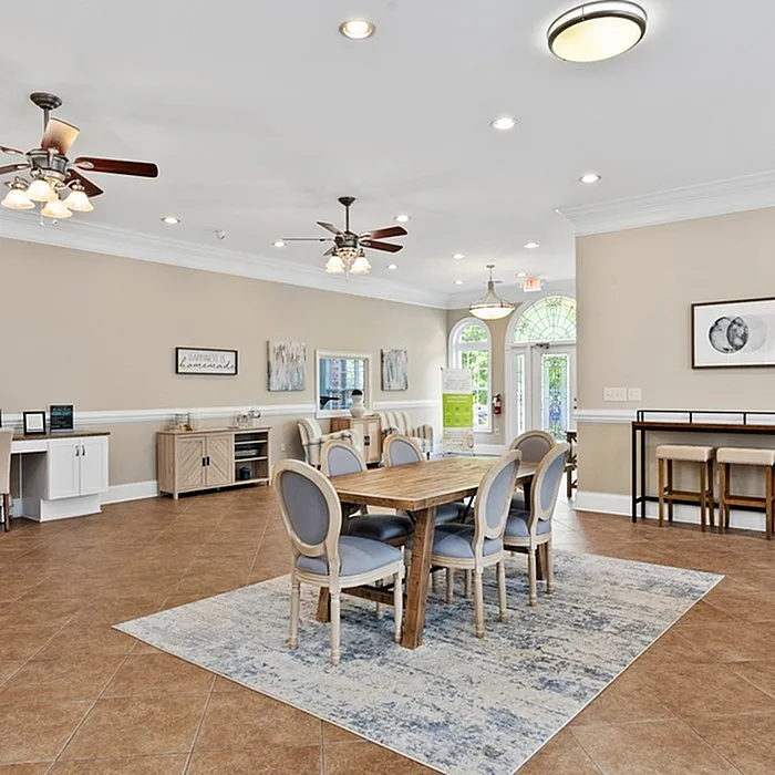 Bright dining area featuring a wooden table with upholstered chairs, ceiling fans, and stylish decor.