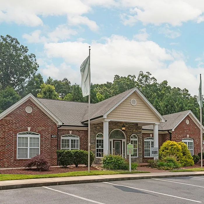 Charming brick community center with lush greenery and a welcoming entrance.
