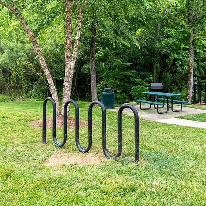 Inviting outdoor space with bike rack, picnic table, and lush green surroundings.