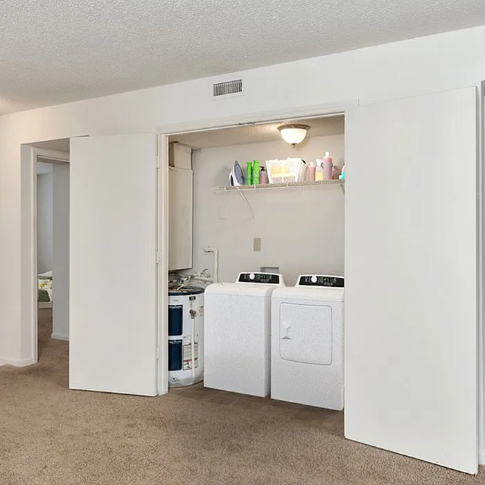 Bright laundry area with modern washer and dryer in a cozy apartment setting.