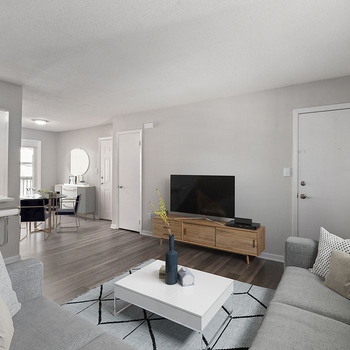 Modern living room with sleek decor, featuring a cozy sofa, stylish coffee table, and a large TV on a wooden stand.
