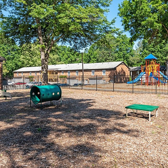 Inviting community playground featuring colorful play structures and lush greenery.