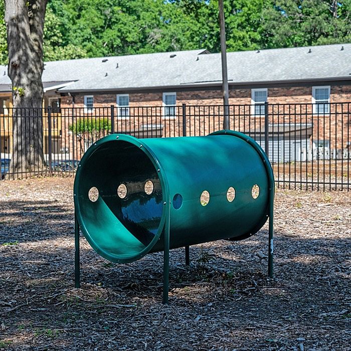 Inviting outdoor play area with a green tunnel structure, perfect for children's activities.