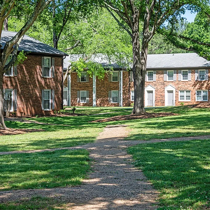 Charming apartment buildings surrounded by lush greenery and tree-lined paths.