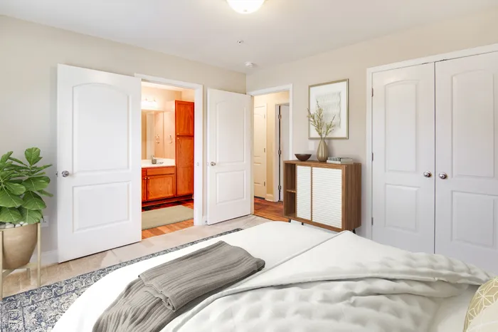Spacious bedroom with elegant decor, opening into a modern bathroom.