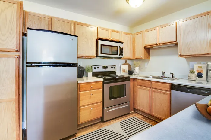 Contemporary kitchen with stainless steel appliances and wood cabinetry, featuring a bright and functional design.