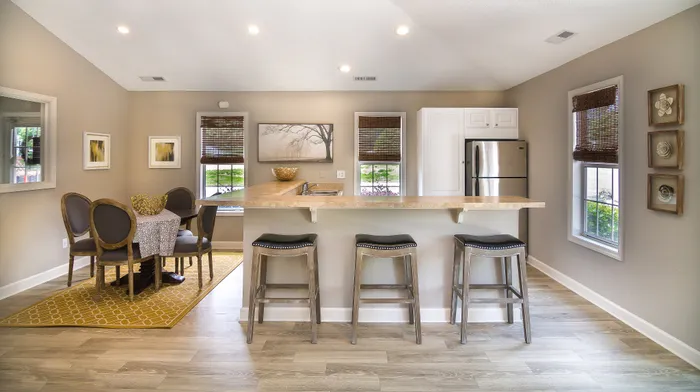 Chic open-concept kitchen and dining area with modern bar stools, stylish decor, and abundant natural light.