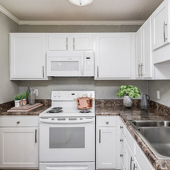 Bright, modern kitchen with sleek white cabinets, elegant countertops, and stylish appliances offering an inviting cooking space.