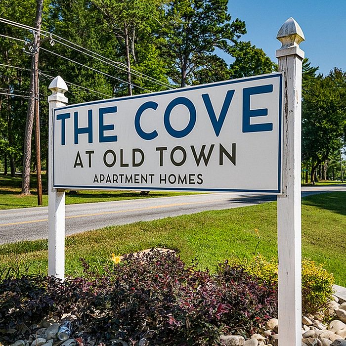 Charming sign for The Cove at Old Town Apartment Homes, surrounded by lush greenery and serene landscapes.