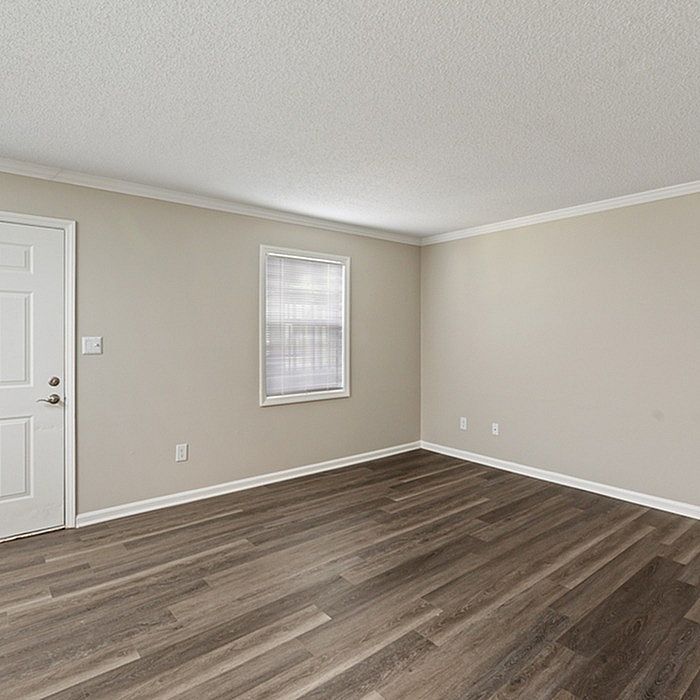 Bright and inviting empty room featuring elegant hardwood flooring and soft beige walls, perfect for customization and decor inspiration.