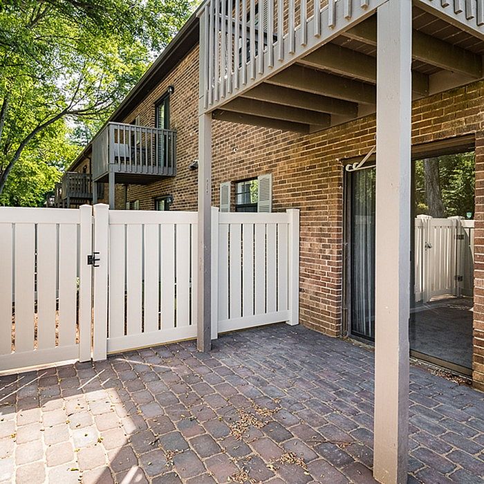 Charming apartment patio with modern fencing, nestled beside a beautifully landscaped garden area, perfect for outdoor relaxation.