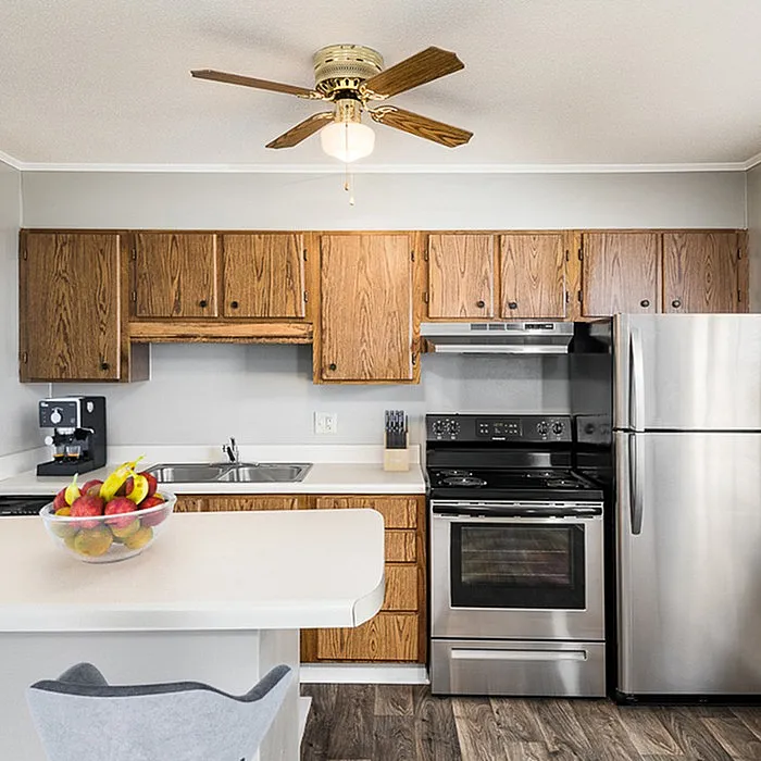 Modern kitchen with sleek stainless steel appliances, warm wooden cabinets, and inviting countertop space.