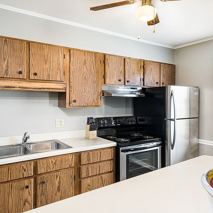 Charming kitchen featuring stainless steel appliances, rich wooden cabinetry, and a spacious countertop perfect for culinary creations.
