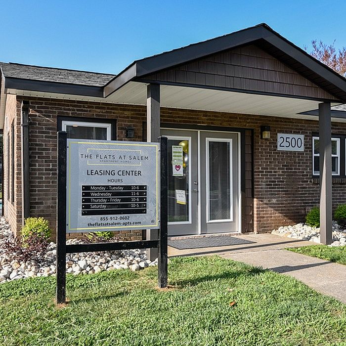 Inviting leasing center of The Flats at Salem with elegant brick exterior and welcoming entrance sign.