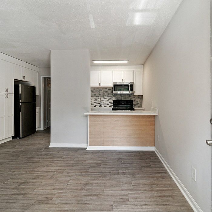 Chic open-concept kitchen with modern appliances, sleek cabinetry, and stylish backsplash, perfect for urban living.