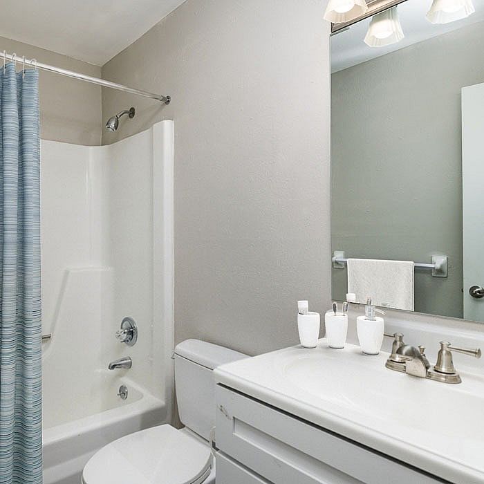 Bright and modern bathroom with elegant fixtures, a sleek vanity, and a refreshing shower area.