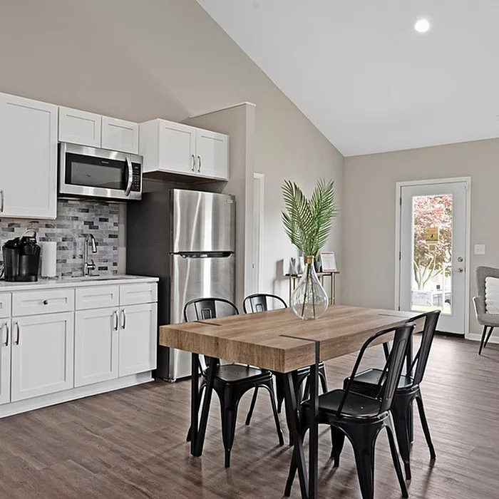 Contemporary kitchen with stainless steel appliances, sleek cabinetry, and a chic dining area with modern decor, perfect for entertaining.