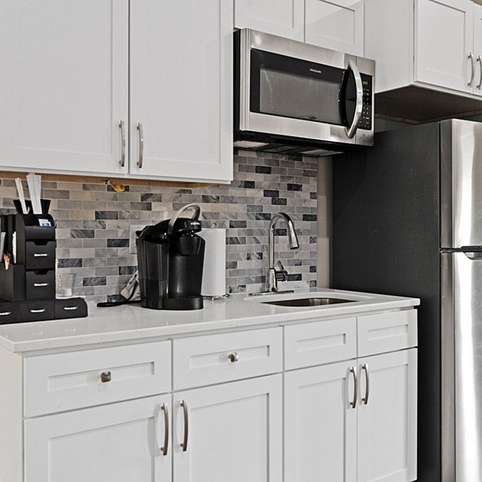 Modern kitchen with sleek stainless steel appliances, elegant white cabinetry, and stylish tile backsplash.