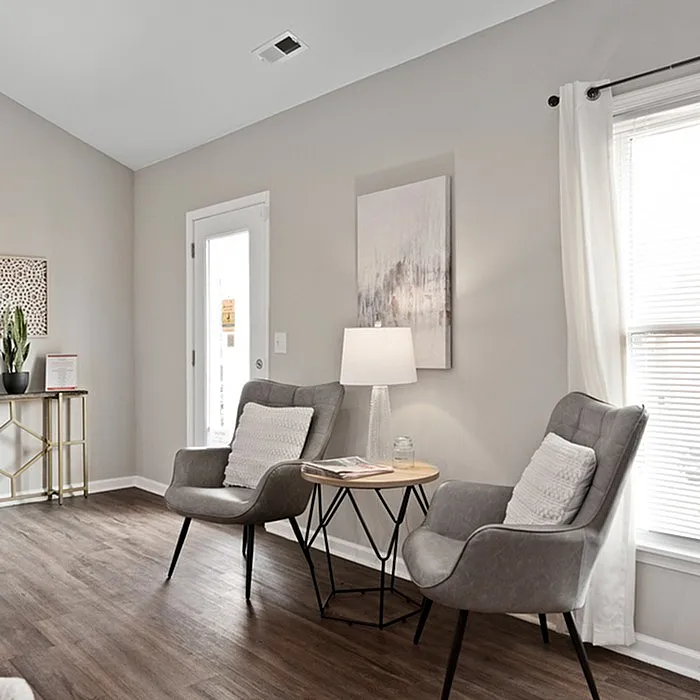 Chic and cozy living area with elegant chairs, stylish side table, and bright natural light.