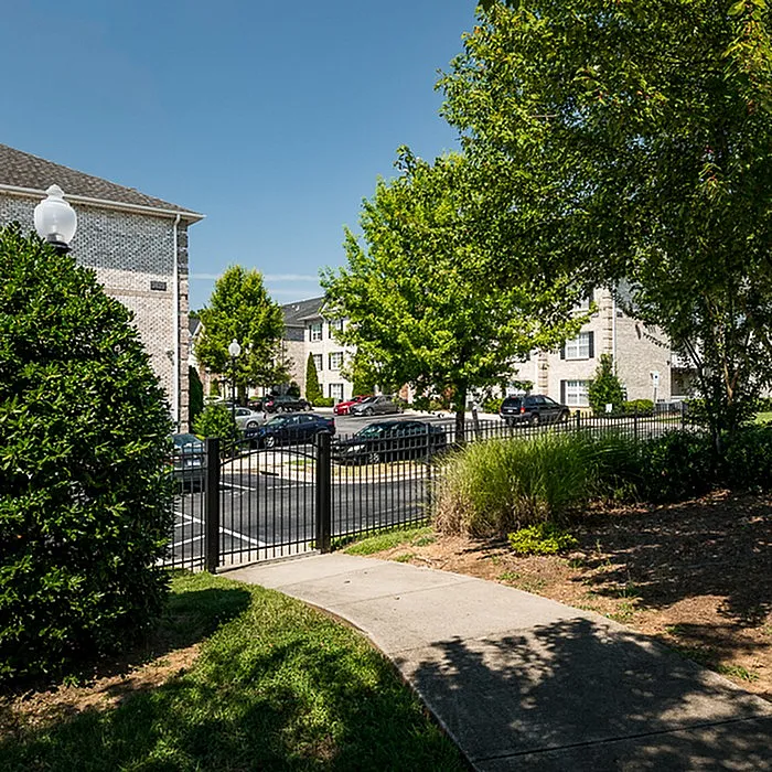 Charming apartment complex surrounded by lush greenery and paved walkways, offering a serene and welcoming environment.