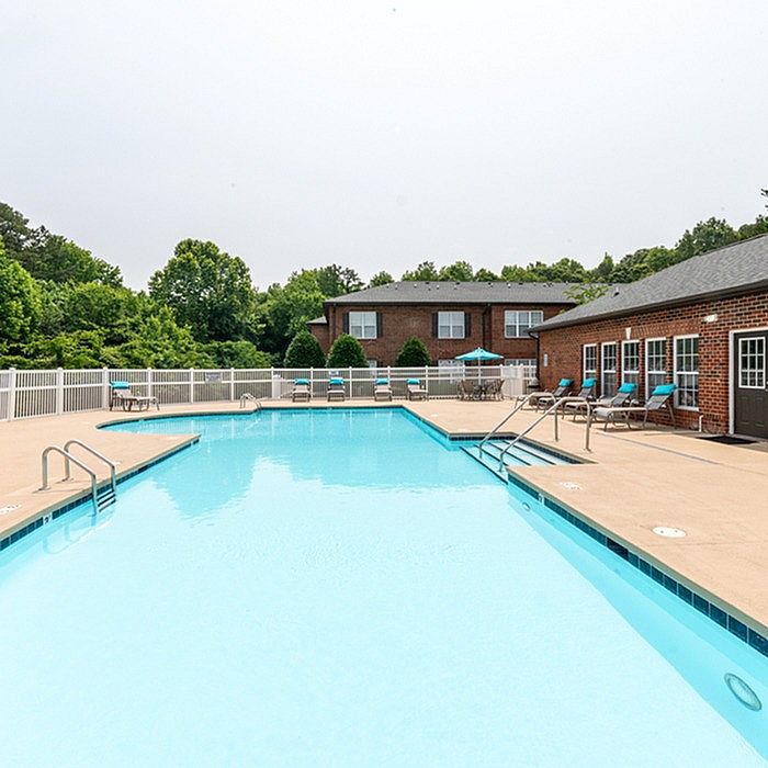 Inviting outdoor pool area with lounge chairs and scenic greenery, perfect for relaxation and summer enjoyment.