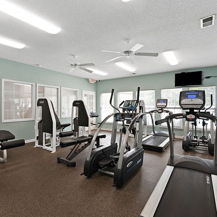 Inviting fitness center equipped with modern exercise machines, natural light, and vibrant ambiance for an energizing workout experience.