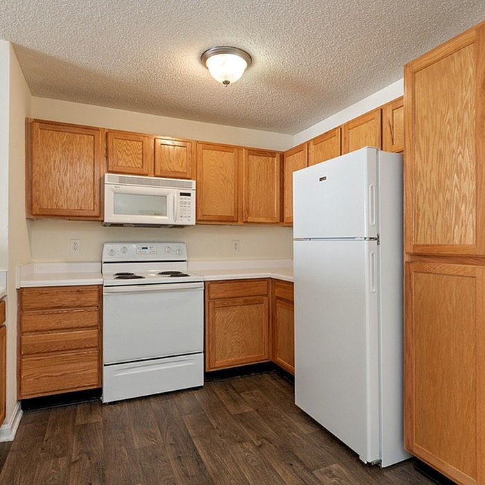 Inviting kitchen space with warm wooden cabinets, sleek appliances, and elegant lighting.