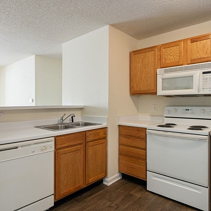 Cozy kitchen with modern white appliances, wooden cabinets, and a sleek countertop, perfect for culinary adventures.