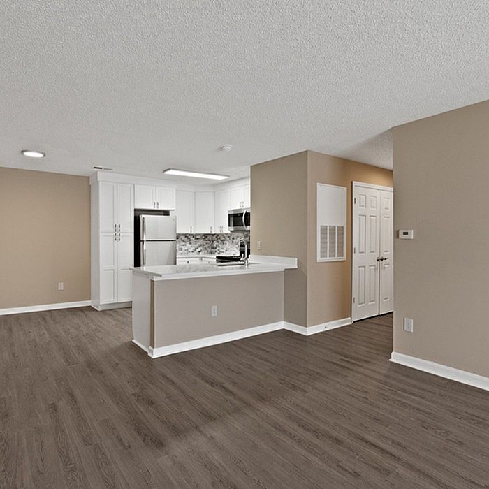 Modern open-concept apartment with sleek hardwood floors, a stylish kitchen with stainless steel appliances, and inviting neutral tones.