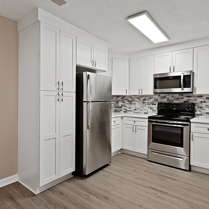 Modern kitchen with sleek stainless steel appliances, elegant white cabinetry, and a stylish backsplash for a contemporary feel.