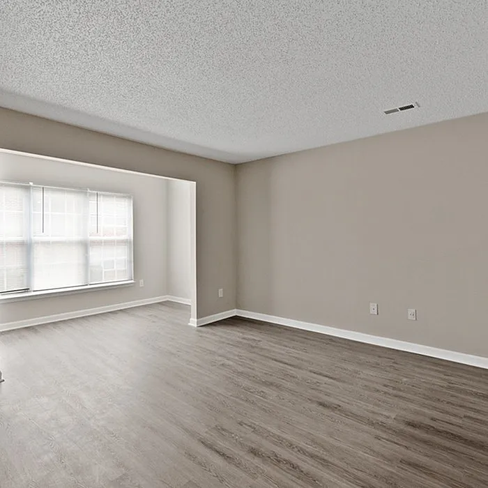 Bright and spacious living room with elegant wood flooring and large windows for natural light.