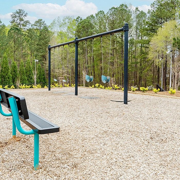 Charming outdoor play area with swings and vibrant greenery, perfect for family fun and relaxation.