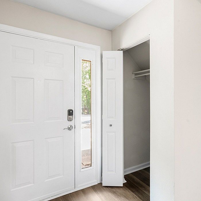 Bright entryway with sleek modern door, smart lock, and convenient closet space on elegant flooring.
